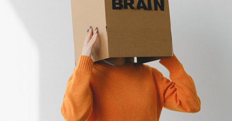 Reconnecting Purpose - Crop person putting Idea title in cardboard box with Brain inscription on head of female on light background