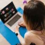 Healthy Social Media - Woman sitting on mat and surfing internet on laptop
