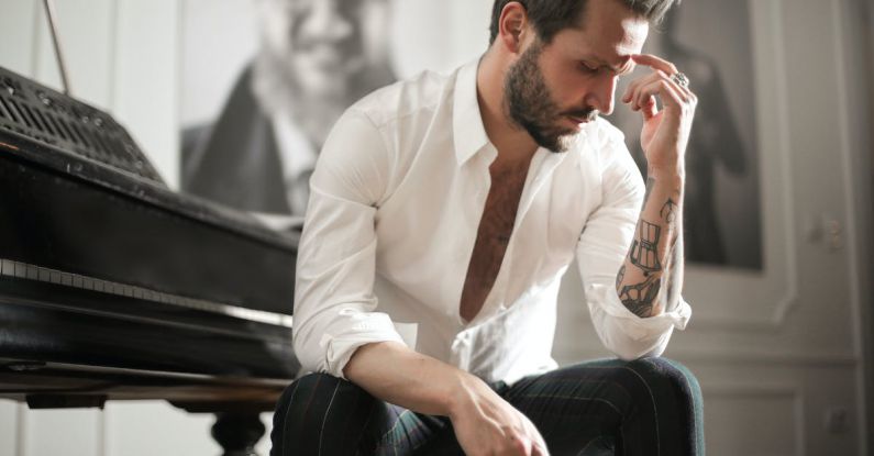 Personalization Experience - Dramatic tattooed male sitting at piano