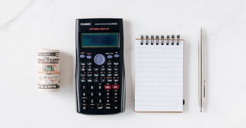 Financial Tools - Composition of calculator with paper money and notebook with pen