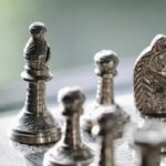 Strategy Challenges - Metal chess pieces on board in room